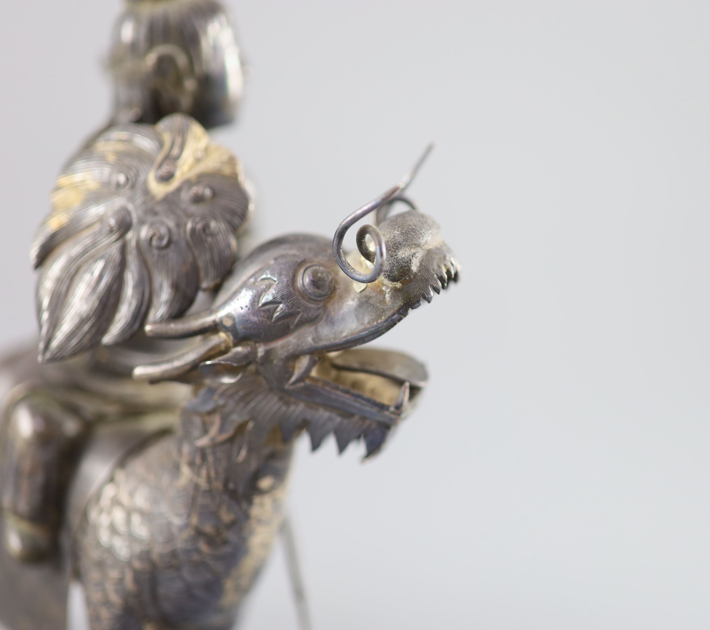 A Chinese white metal model of a boy riding a qilin , early 20th century, 12.5cm long